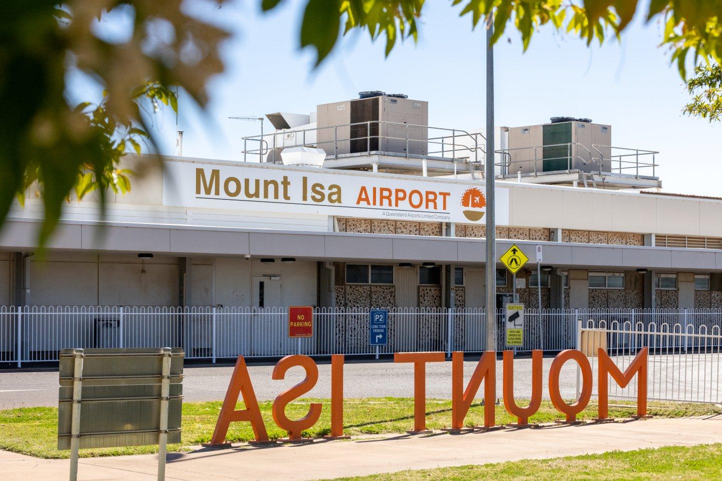 Exterior view of Mount Isa Airport building with signage and air conditioning units.